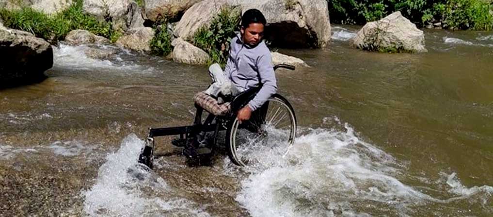 surya-adhikaris-wheelchair-helps-him-through-potholes-rivers-with-no-bridge